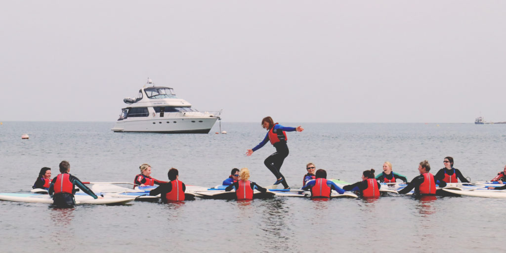 a woman running Across a bunch of paddleboards in the water