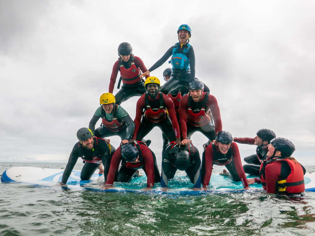 a stag do creating a human pyramid on a jumbo paddleboard