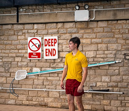 pool lifeguard stood on the edge of the pool