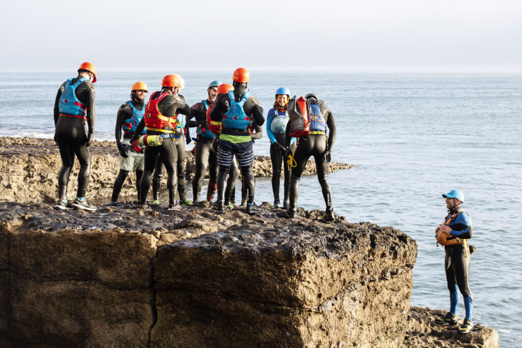A group of outdoor instructors coasteering at the dancing ledge. 