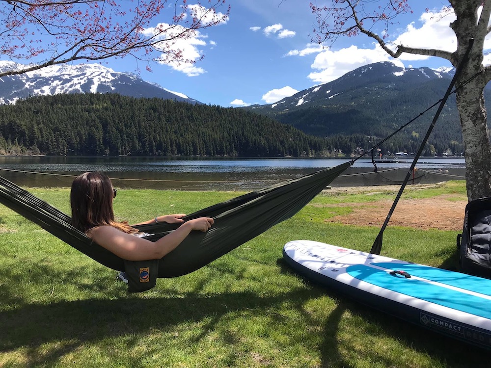 Person finding the balance between work and home by relaxing in a hammock outdoors 