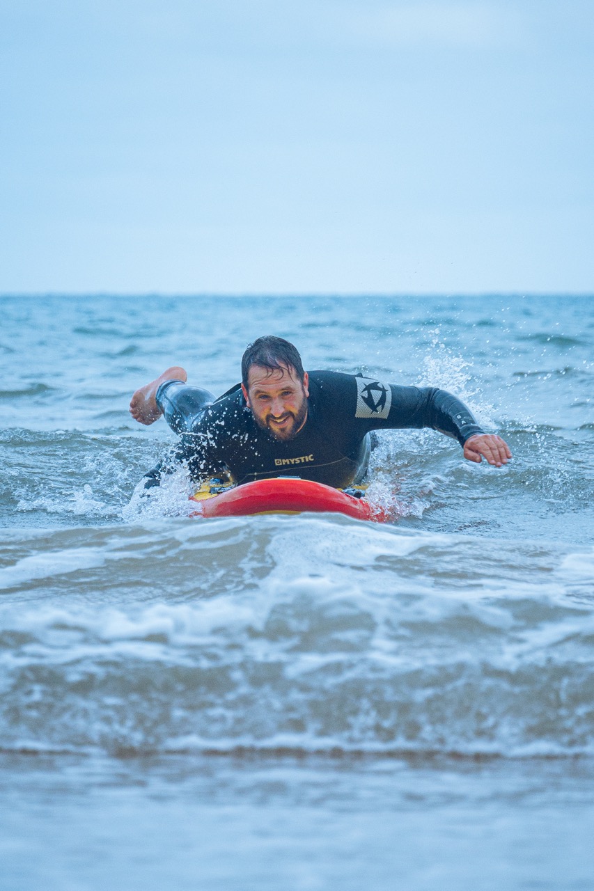 an instructor riding a wave back into shore