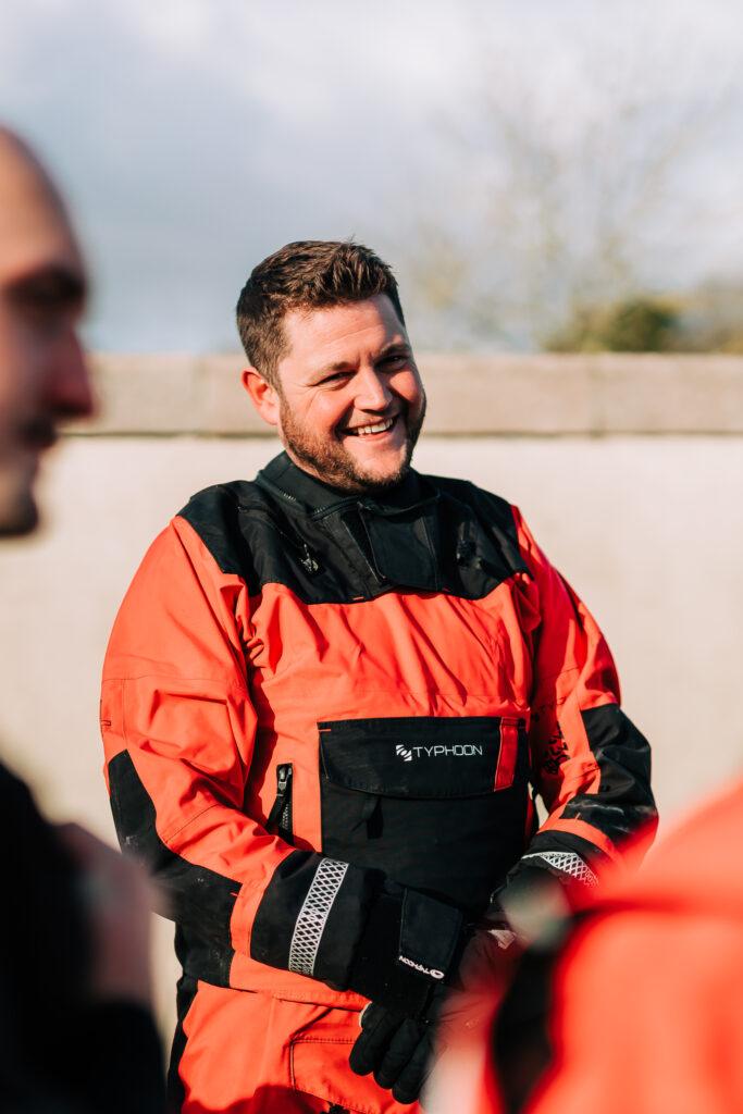 A man smiling in a dry suit