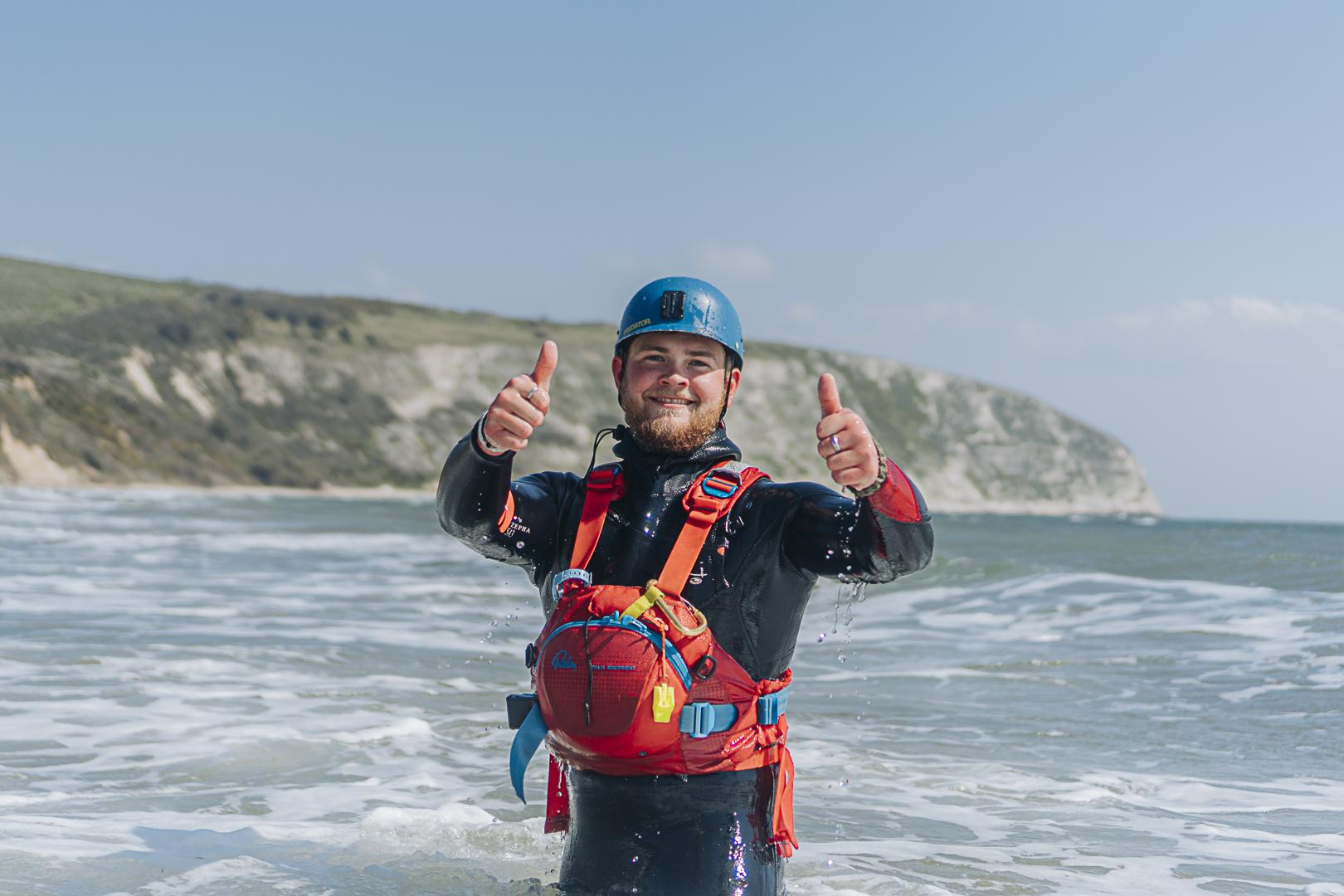 Outdoor Instructor with his thumbnails up at the beach