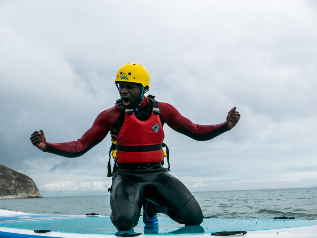 Man cheering on a jumbo paddle boarding