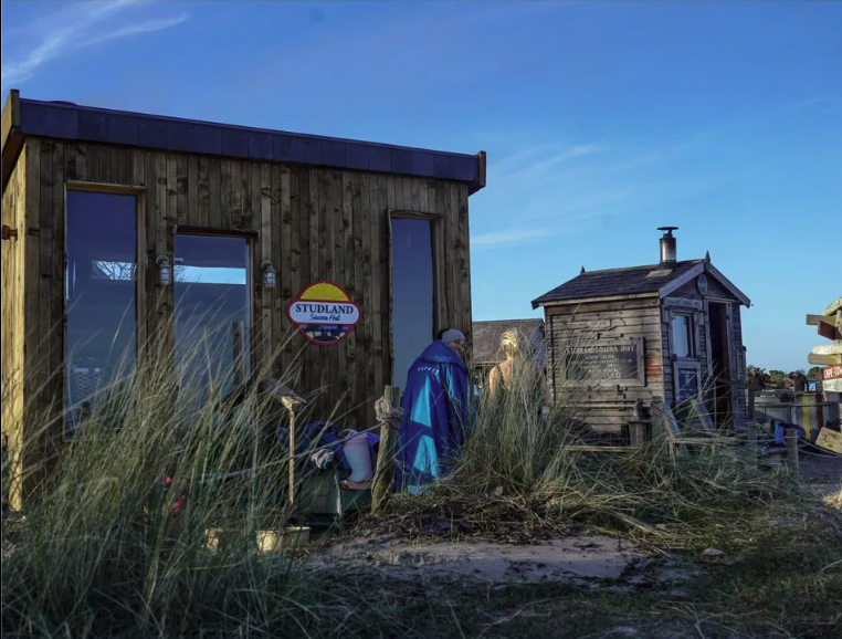 A photo of the Studland Sauna Huts on the beach in the sunshine.