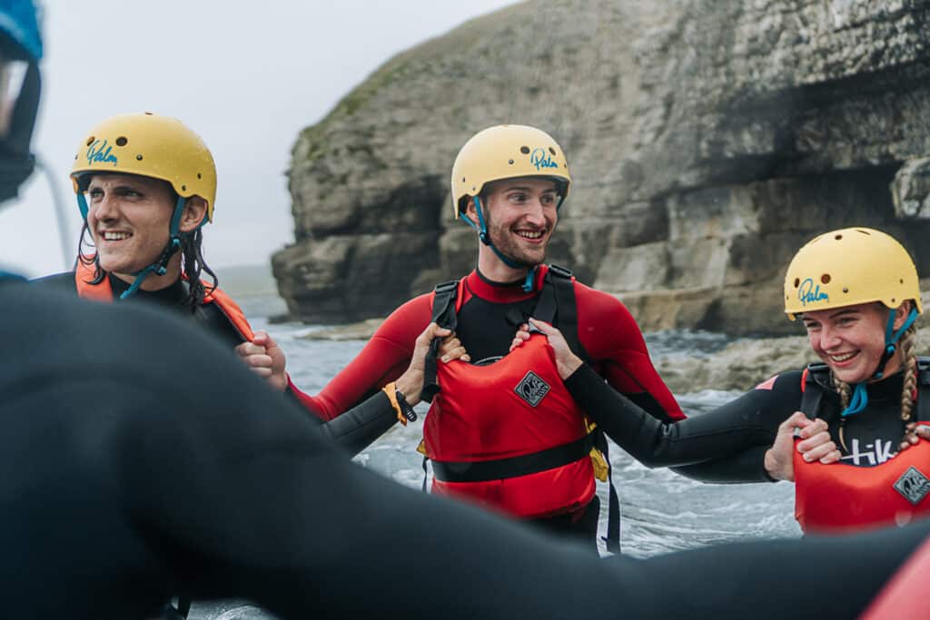 Outdoors, in the sea, group holding onto each other, smiling - Neurodiversity Jobs