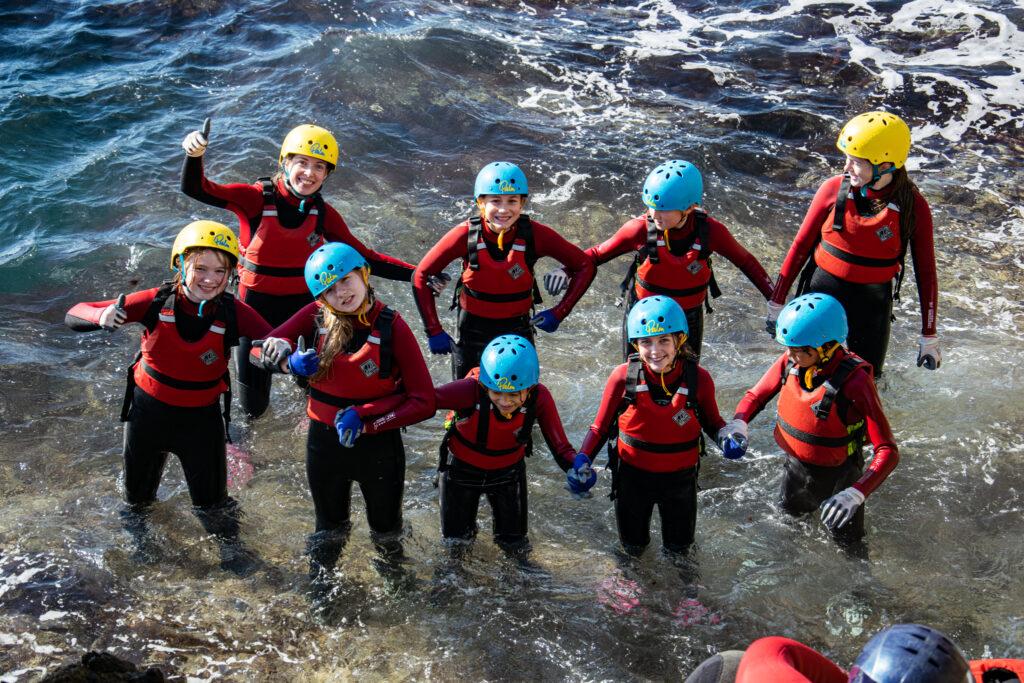 Kids Smiling in the ocean on a day trip with Land & Wave